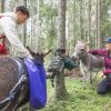 Evästauolla metsäretkellä, jolloin aasit syövät heiniään ja hymyilevät ihmiset silittelevät niitä